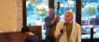 male singer in front of his band at a restaurant